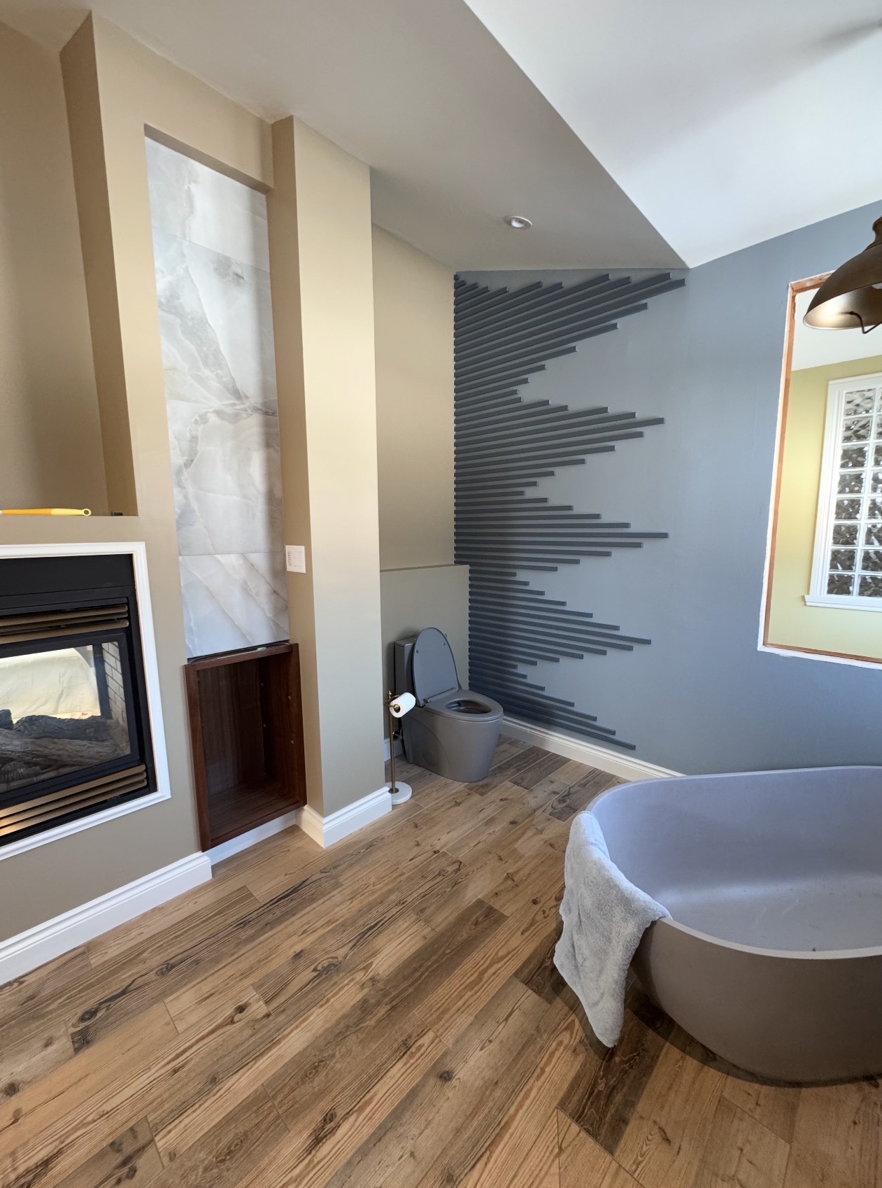 Floor-to-ceiling herringbone tile ensuite with freestanding soaker tub — bathroom renovation in Orléans, Ontario